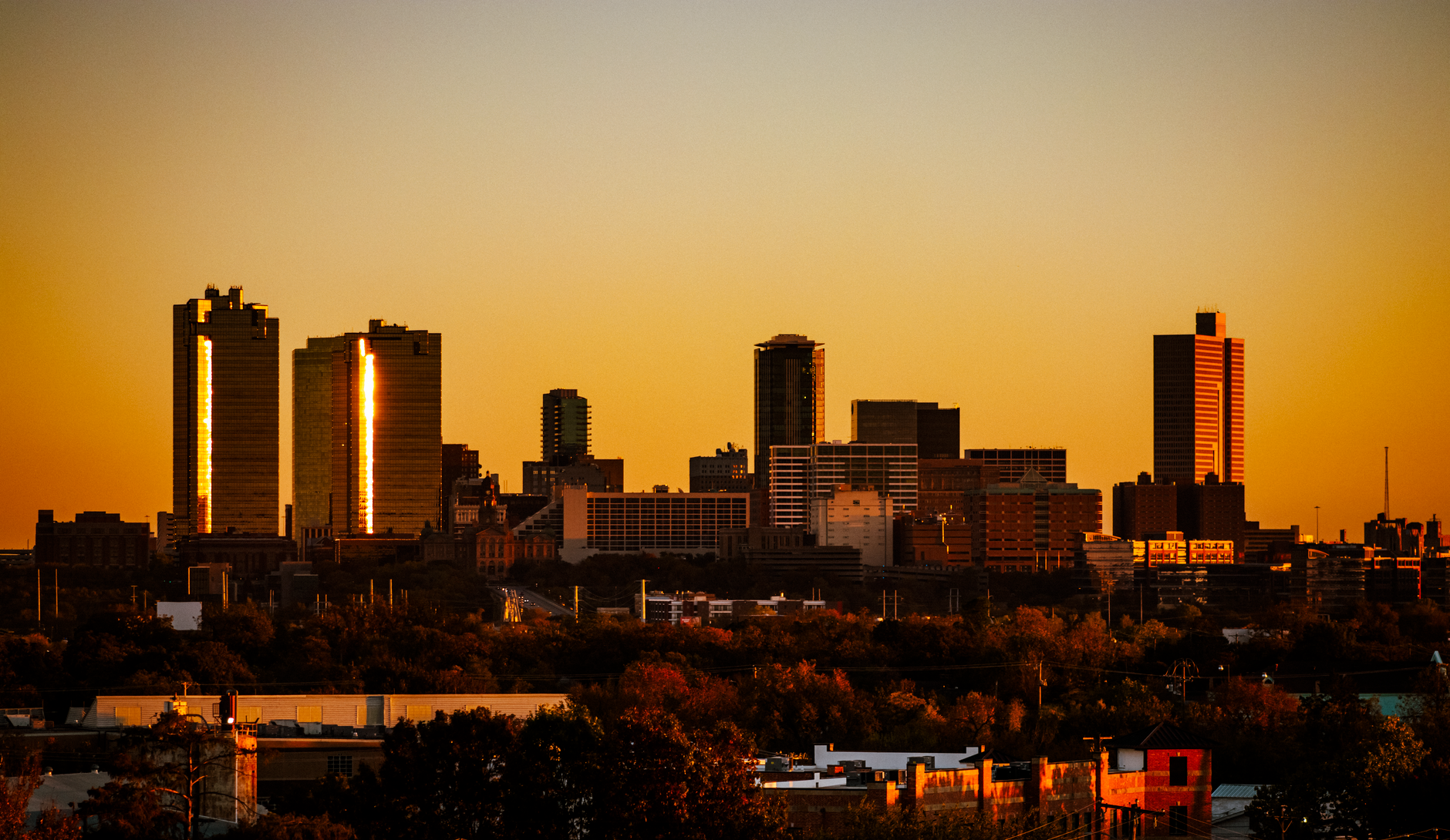 Dramatic sunset view of Fort Worth, Texas skyline. Warm tones highlight the city's architecture.