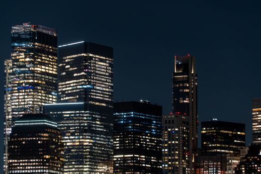 Explore the dazzling skyline of Manhattan with illuminated skyscrapers at night, showcasing New York City's vibrant architecture.