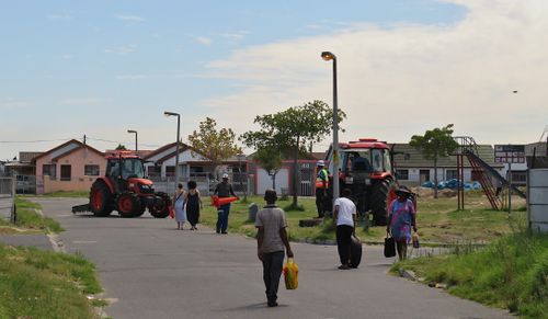 Free Urban street view with pedestrians and tractors on a sunny day. Stock Photo