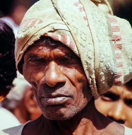 Free Close-up portrait of an Indian farmer wearing a traditional headwrap in a rural setting. Stock Photo