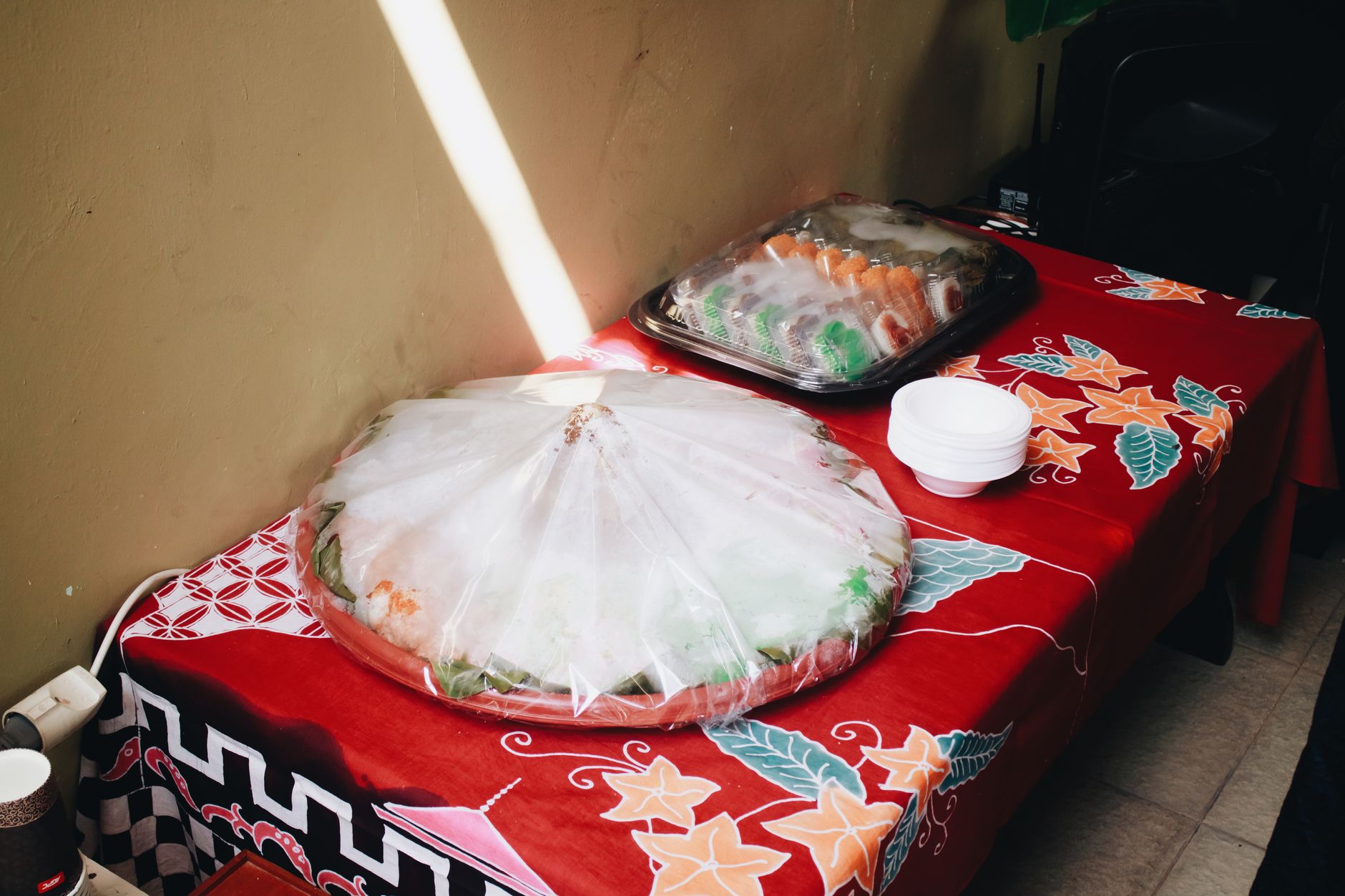 Indonesian street food covered and arranged on a vibrant tablecloth in Bandung.