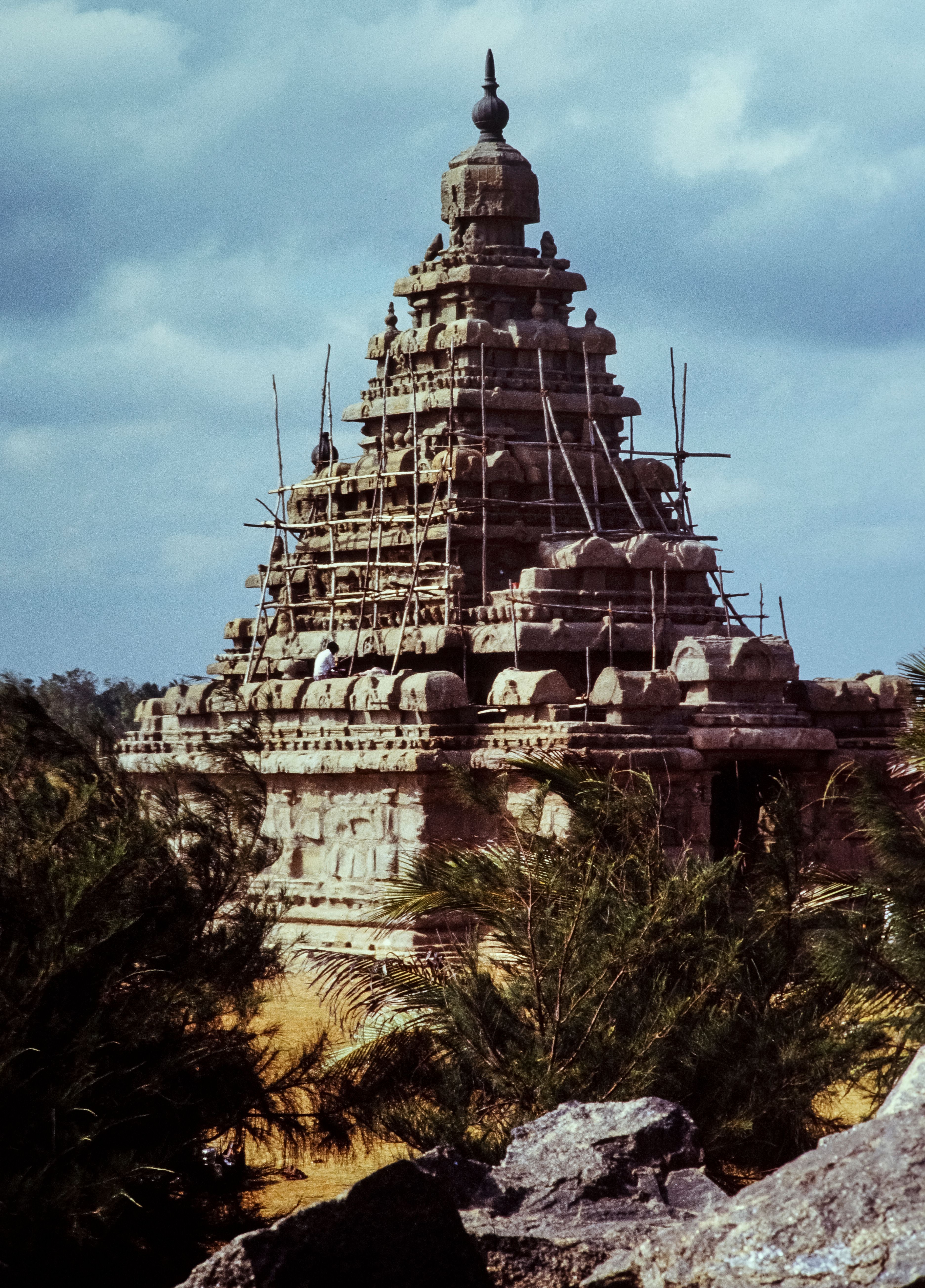Majestic ancient temple in India with scaffolding for restoration, under a vibrant sky.