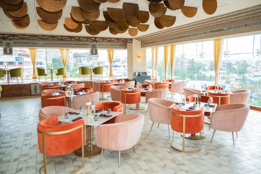Stylish rooftop restaurant featuring vibrant seating and modern decor with panoramic city views.