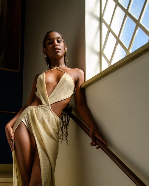 Free Elegant photo of a woman in a stylish dress by a sunlit window in São Paulo. Stock Photo