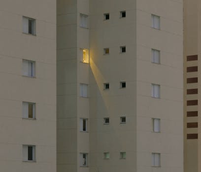 夜晚，一栋现代化公寓楼亮着灯的窗户构成了引人注目的焦点