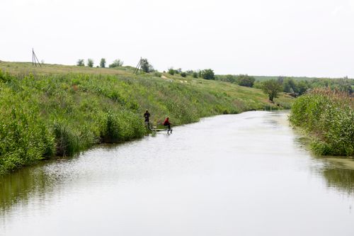 Free Serene image of fishermen on a river surrounded by lush greenery and gentle hills. Stock Photo