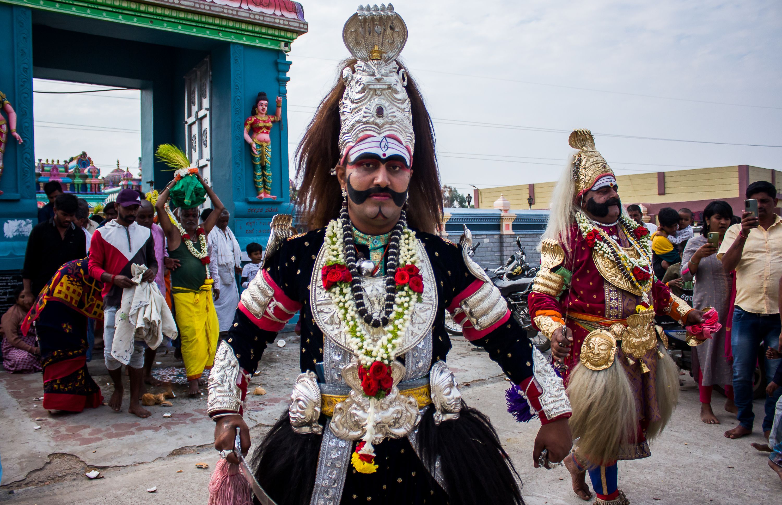 Vibrant traditional Indian festival with performers in elaborate costumes and makeup, showcasing cultural heritage.