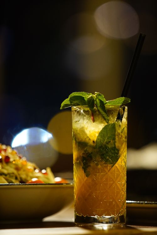 Free A close-up of a refreshing mint cocktail with blurred bokeh lights, perfect for a vibrant evening. Stock Photo