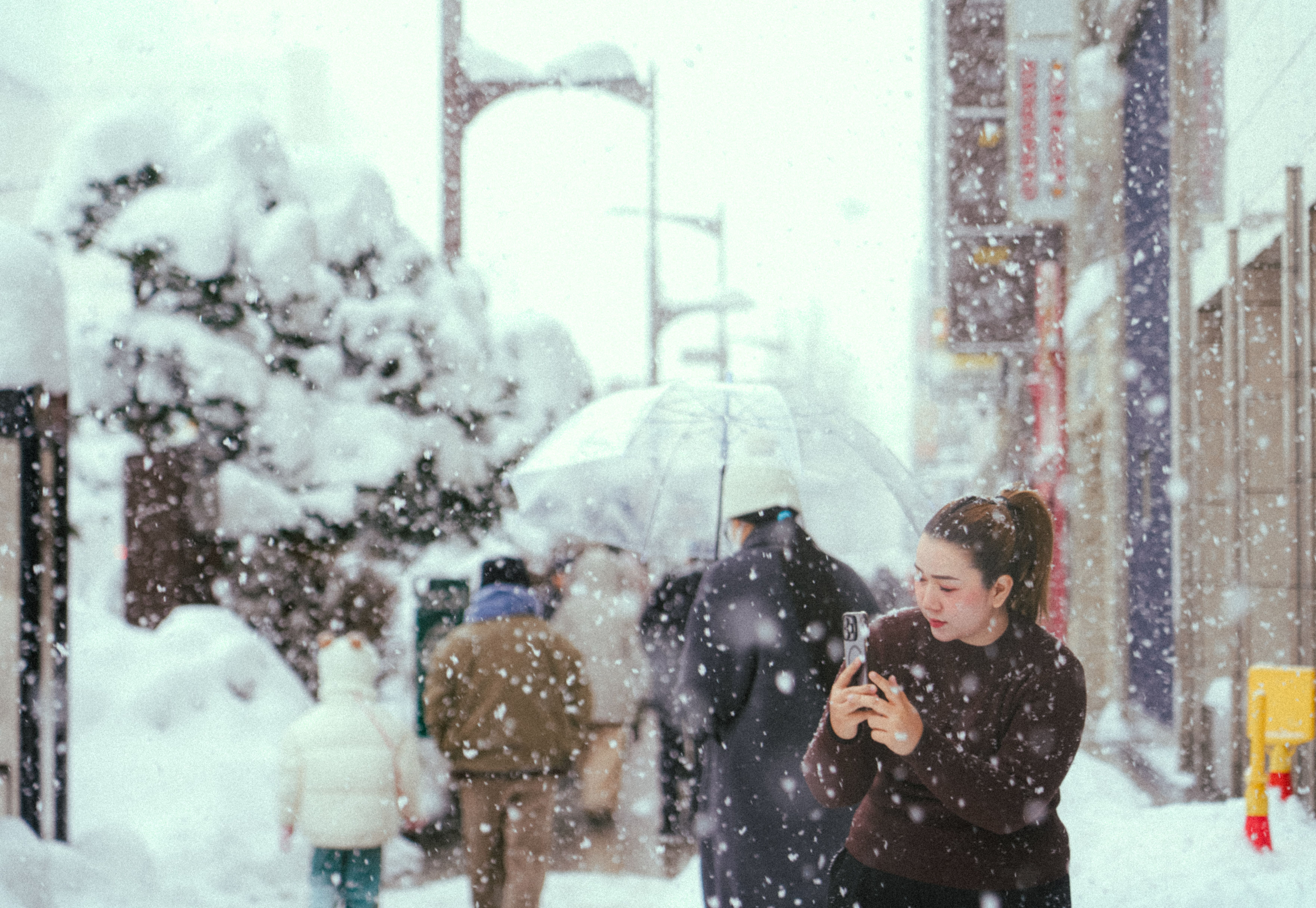 Gratis Una strada invernale in Giappone con persone in mezzo alla neve che cade, creando una scena pittoresca. Foto a disposizione
