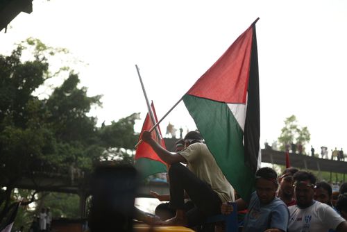 Free Pro-Palestine rally in Dhaka, Bangladesh with demonstrators waving flags in solidarity. Stock Photo
