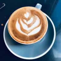 Latte with leaf art in a blue cup — photo by Anne-marie _ on Pexels