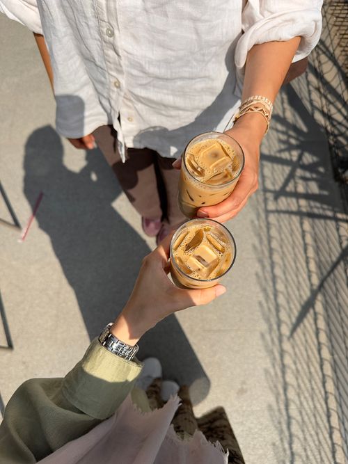 Free Two people toasting iced coffee drinks outdoors in Istanbul sunshine. Stock Photo