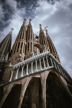 Breathtaking angle of Sagrada Familia's intricate gothic architecture against a dramatic sky.
