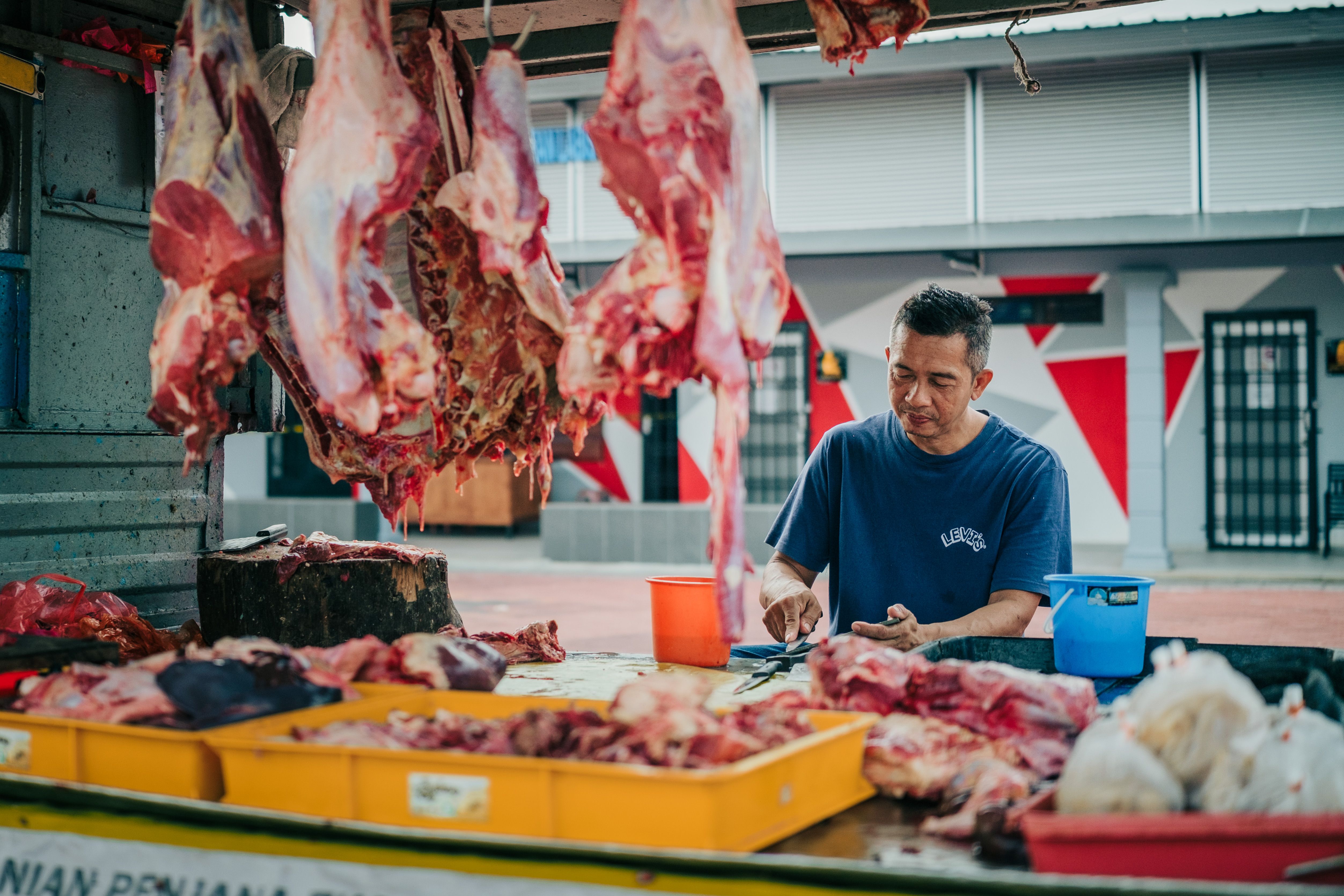 Gratuit Un vendeur de viande prépare des morceaux au marché matinal de Labis, à Johor, en Malaisie. Scène traditionnelle en plein air. Photos