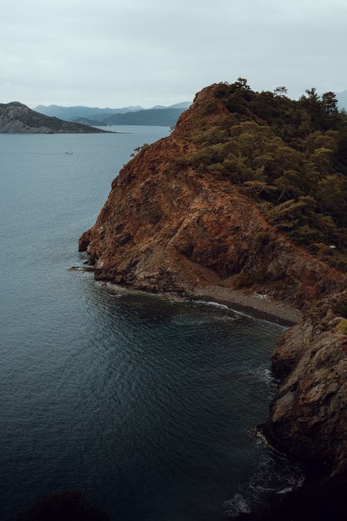 Free Dramatic view of a rocky cliff and the Aegean Sea in Fethiye, Turkey. Stock Photo