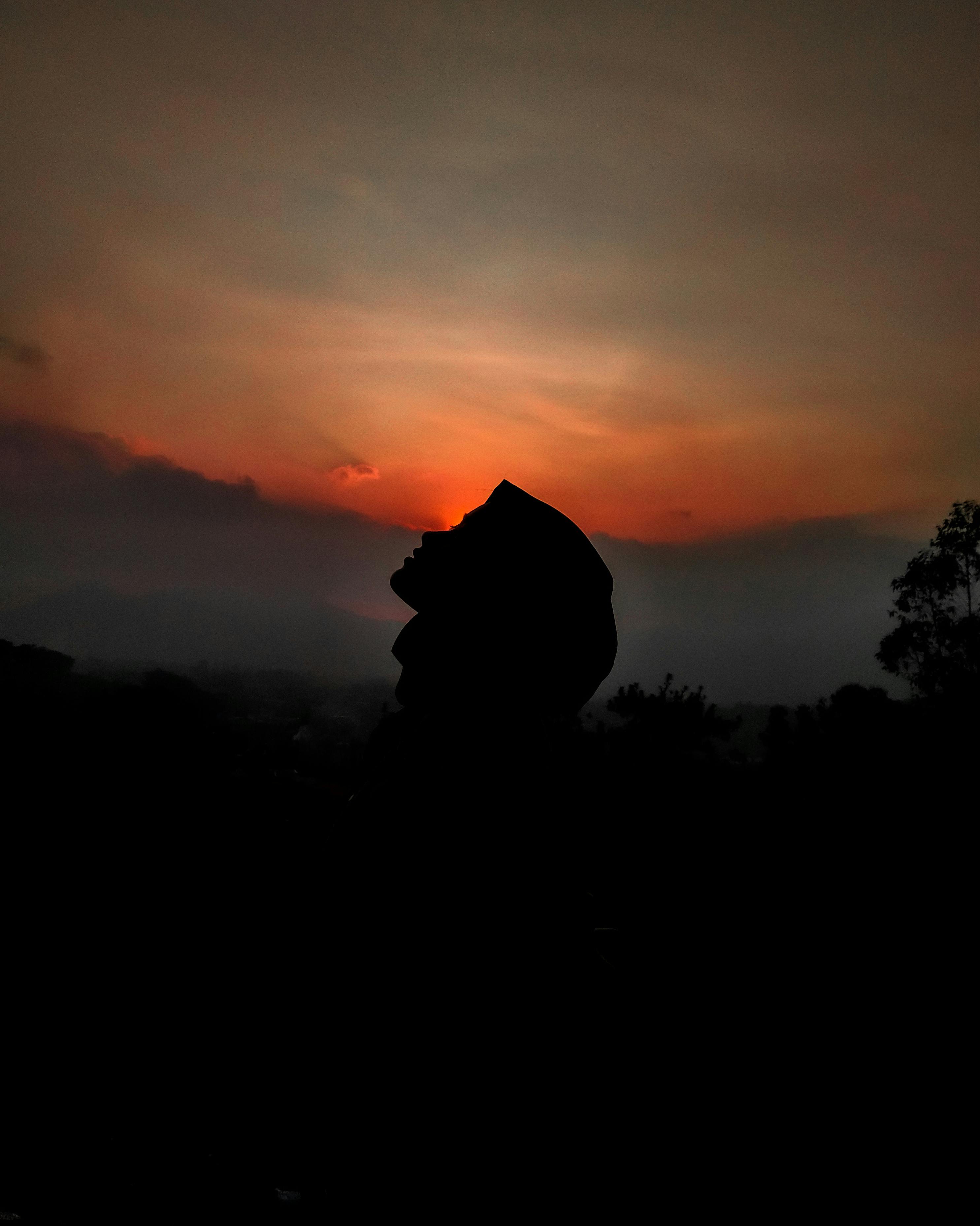 silhouette of person against sunset sky