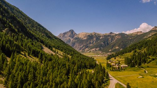 Free Breathtaking aerial view of lush green pine forests and a picturesque valley in the French Alps. Stock Photo