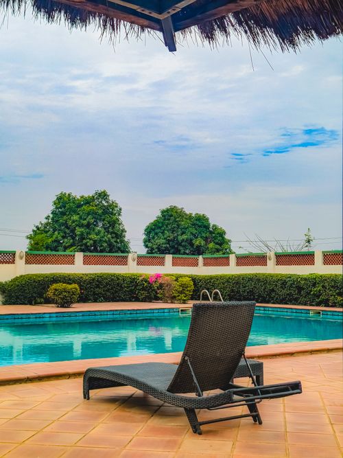 Free A serene view of a poolside lounge area under a blue sky in Abuja, Nigeria. Stock Photo