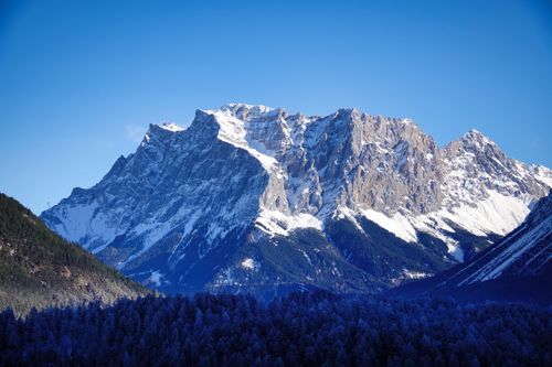 Free Majestic snow-capped mountain range beneath a clear blue sky, epitomizing natural beauty. Stock Photo