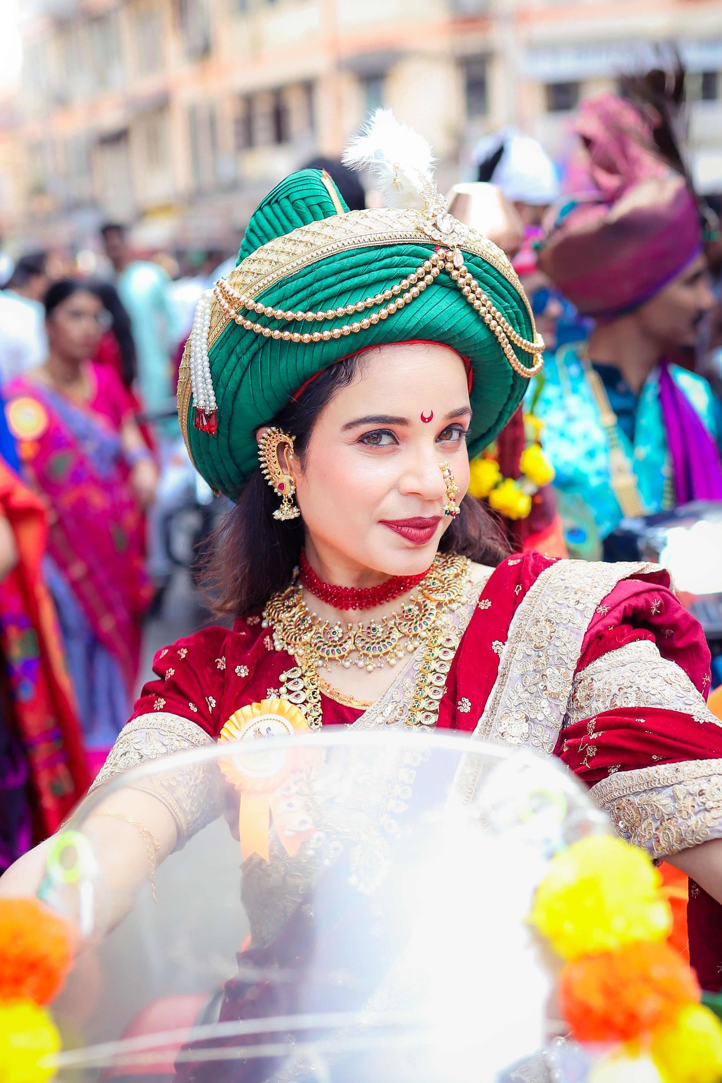 A woman in traditional Maharashtrian attire during a vibrant Indian festival procession in Mumbai.