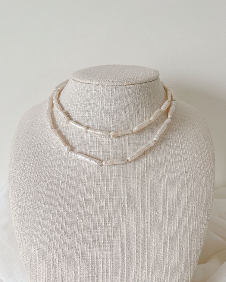 Two-row rice pearl necklace on a linen display bust