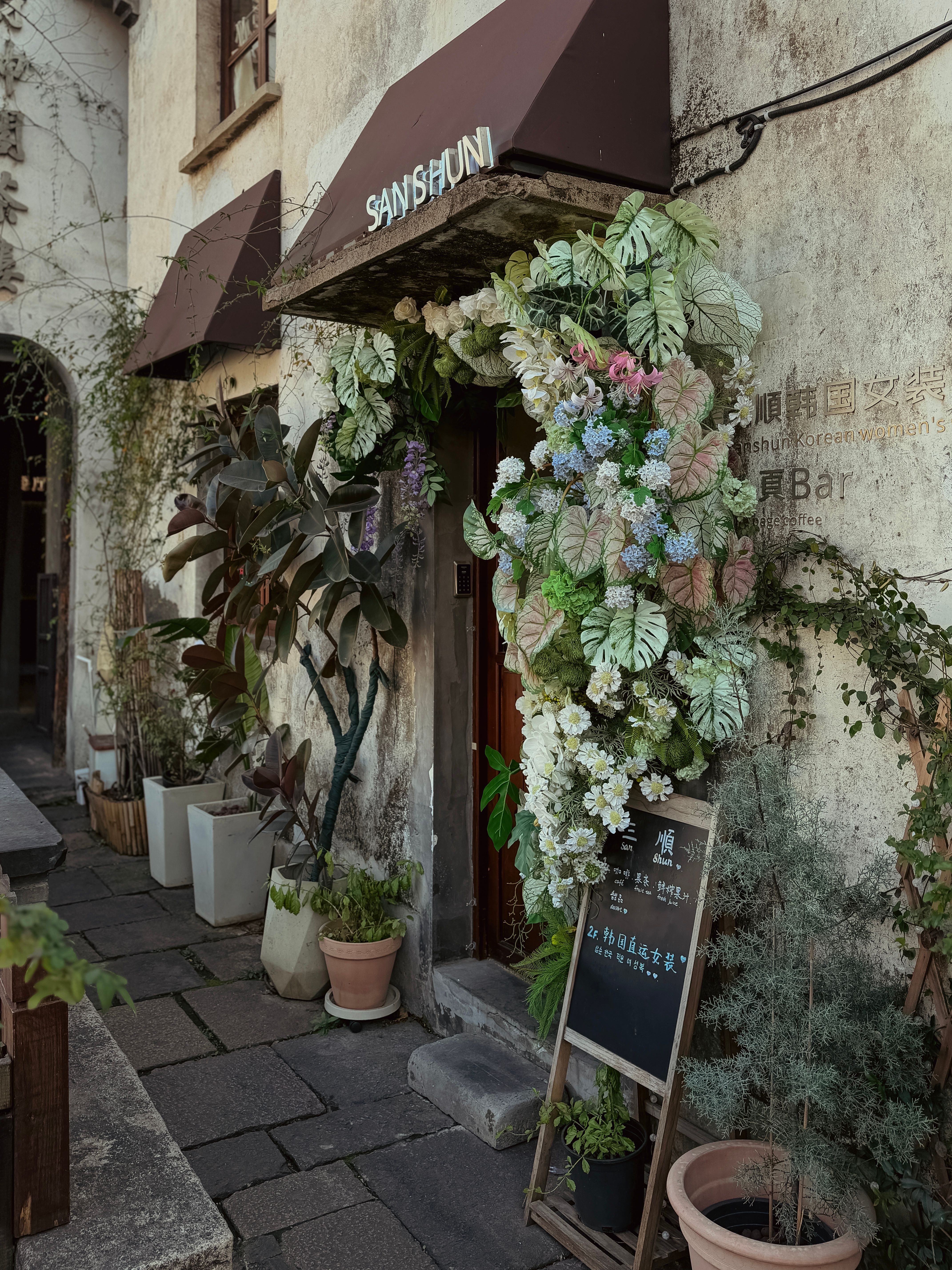 Floral-decorated shop entrance in Nanxun Ancient Town, capturing a rustic and inviting aesthetic.