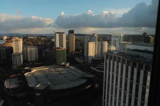Skyline view of a city with high-rise buildings under clouds captured during the day.