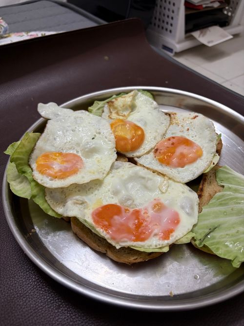 Free Delicious fried eggs served on toast with fresh lettuce, a perfect breakfast dish. Stock Photo