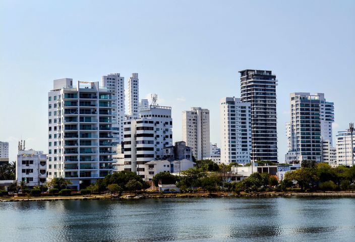 Panoramic view of modern skyscrapers in Cartagena, reflecting on the water during a sunny day.