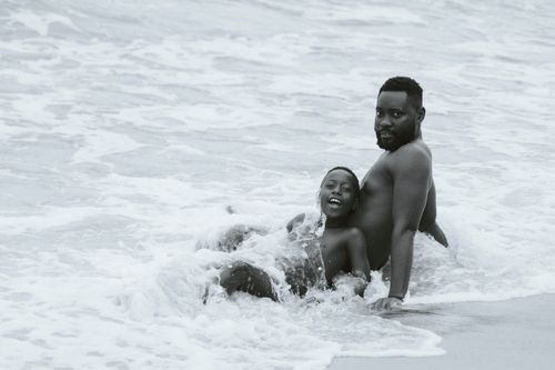 Free Father and son enjoying playful time in the waves at a beach in Liberia. Stock Photo