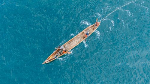 Free Aerial view of a traditional canoe with fishermen navigating the ocean waters near Liberia's coast. Stock Photo