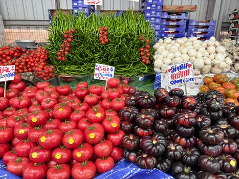 Vibrant array of fresh tomatoes, peppers, and mushrooms at a bustling market in Istanbul, Turkey.