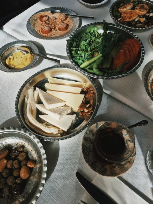 Free A diverse Mediterranean brunch spread featuring cheese, vegetables, nuts, and tea. Stock Photo