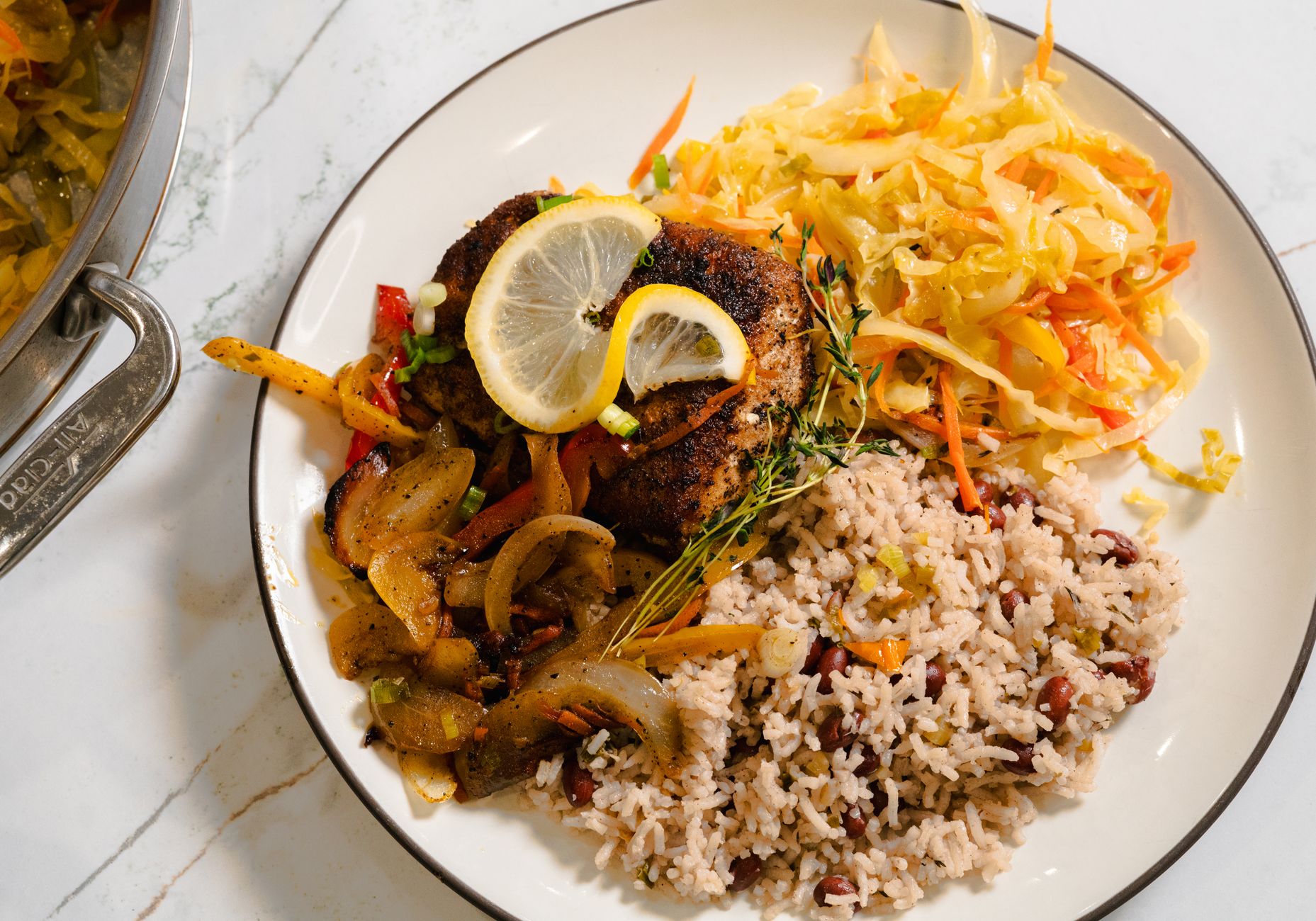 Golden fried snapper topped with colorful pickled onions, carrots, and peppers, drizzled with spiced oil on a white plate