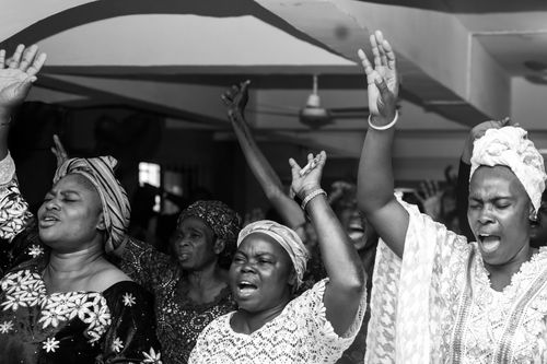 Free Black and white photo capturing African women passionately celebrating indoors in Lagos, Nigeria. Stock Photo