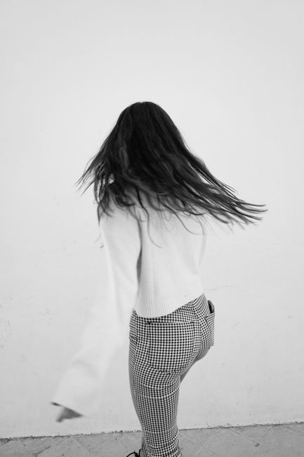 Captivating black and white photo of a woman in motion spinning gracefully.