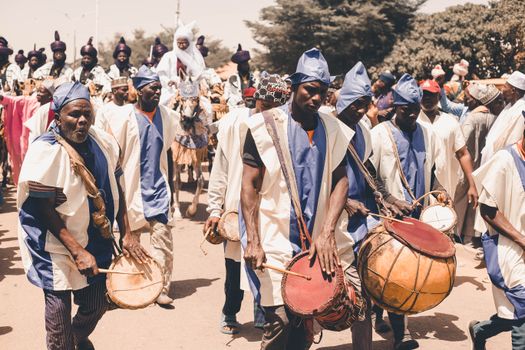 Vibrant street parade featuring African drummers and traditional attire in a lively cultural celebration.