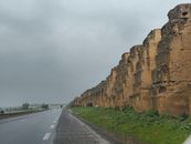 Stormy day showcasing ancient ruins alongside a deserted highway.