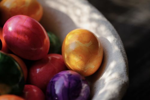 Free A close-up of colorful Easter eggs in a basket, bathed in soft morning light. Stock Photo