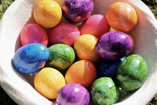 A collection of brightly colored Easter eggs nestled in a basket, perfect for celebrating the springtime holiday.