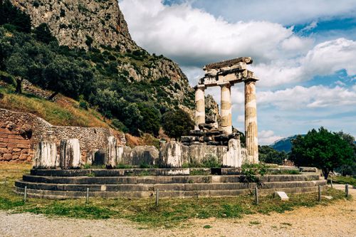 Free Explore the ancient temple ruins of Delphi set against a mountainous backdrop in Greece. Stock Photo