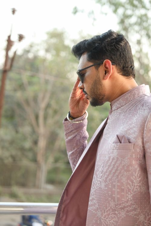 Free Side profile of a stylish man in traditional attire, wearing sunglasses, outdoors during the day. Stock Photo