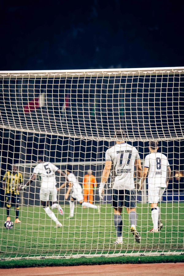 Intensiv fotbollsmatch under stadionljus