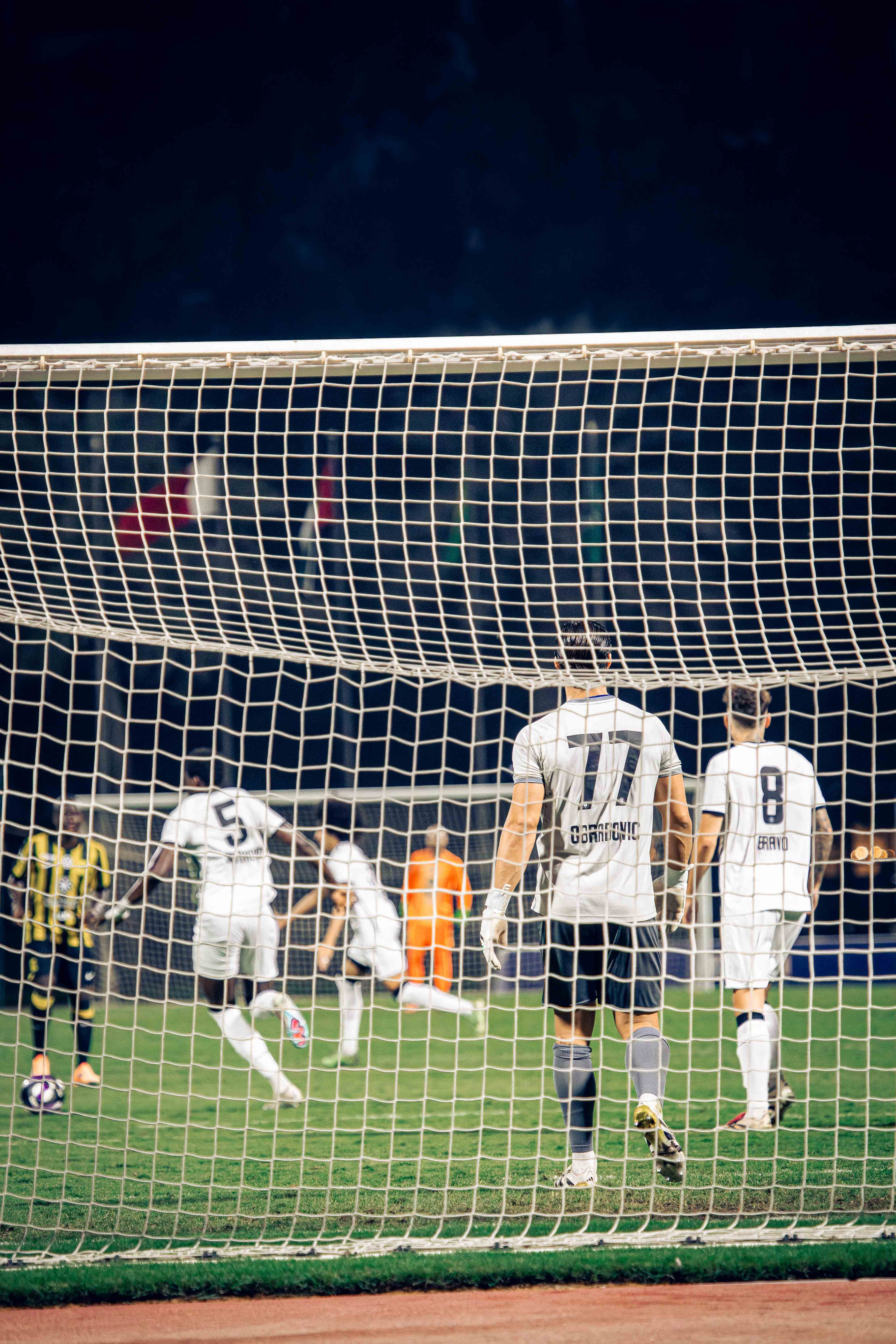 Intense Soccer Match Under Stadium Lights