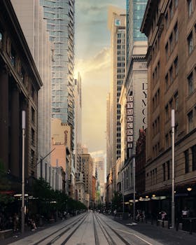 Majestic cityscape of Sydney's downtown during golden hour with tram tracks.