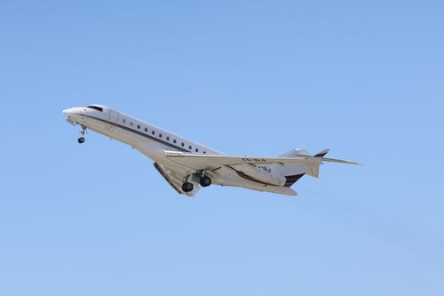 Free A private jet ascending in clear blue skies, showcasing modern air travel. Stock Photo