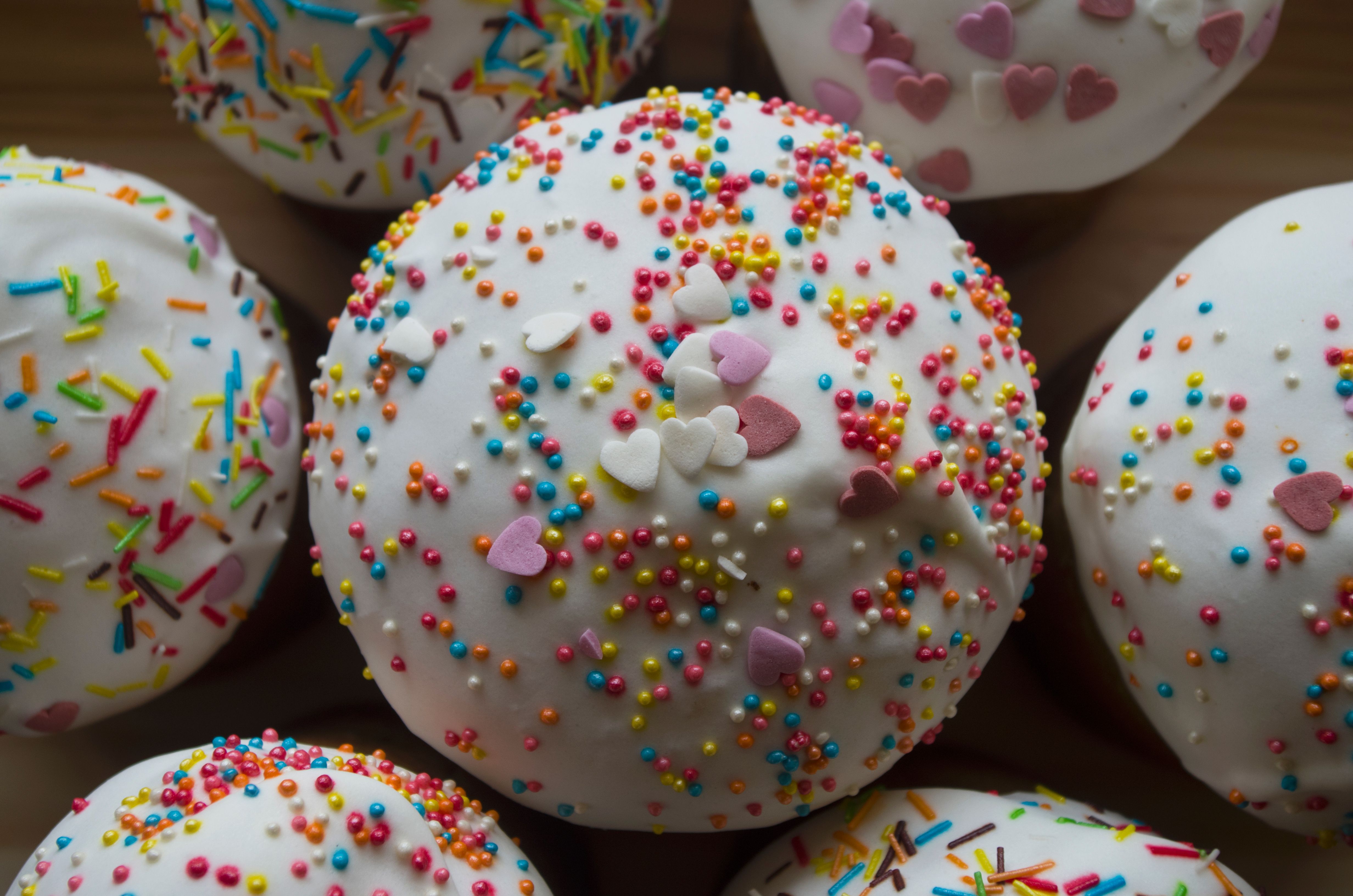 Close-up of cupcakes topped with white icing and colorful sprinkles, perfect for celebrations.