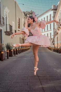 Ballerina in pink costume dancing gracefully on a charming street in Puebla, Mexico.
