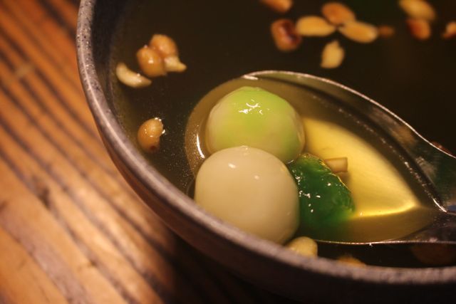 Close-up of tangyuan dessert with nuts in a bowl, showcasing vibrant colors and textures.