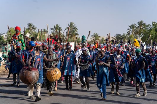 Vibrant cultural procession featuring traditional attire and drummers in Dutse, Nigeria.
